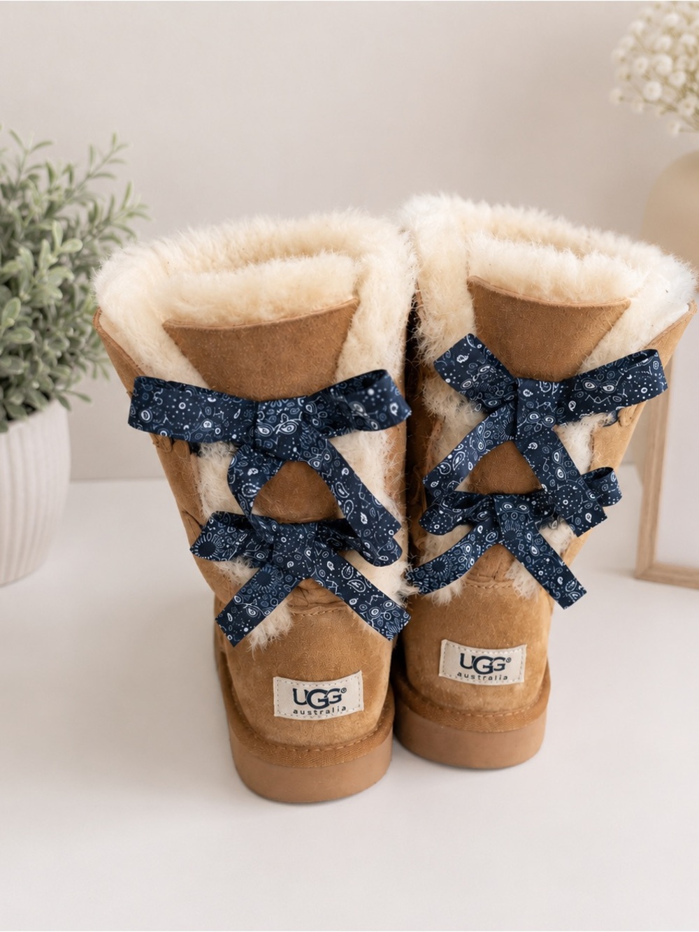 UGG Kids Tan Shearling Boots with Navy Bow Accents